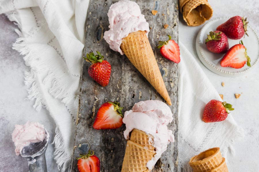 cones with strawberry ice cream and strawberries around