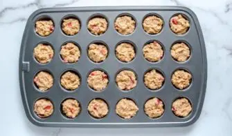 muffin batter scooped inside a mini muffin pan