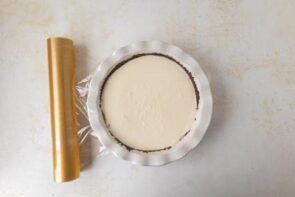 Cream filling poured into the prepared pie crust and covered with plastic wrap to chill.