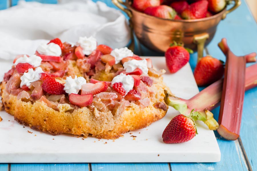 keto strawberry rhubarb bundt cake with whipped cream dolloped on top