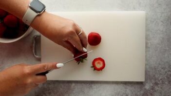 cutting the tops off of strawberries