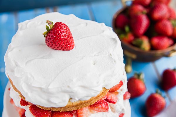 fluffy homemade keto whipped cream spread on top shortcake with a strawberry on top