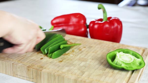 chopping green bell peppers with a knife