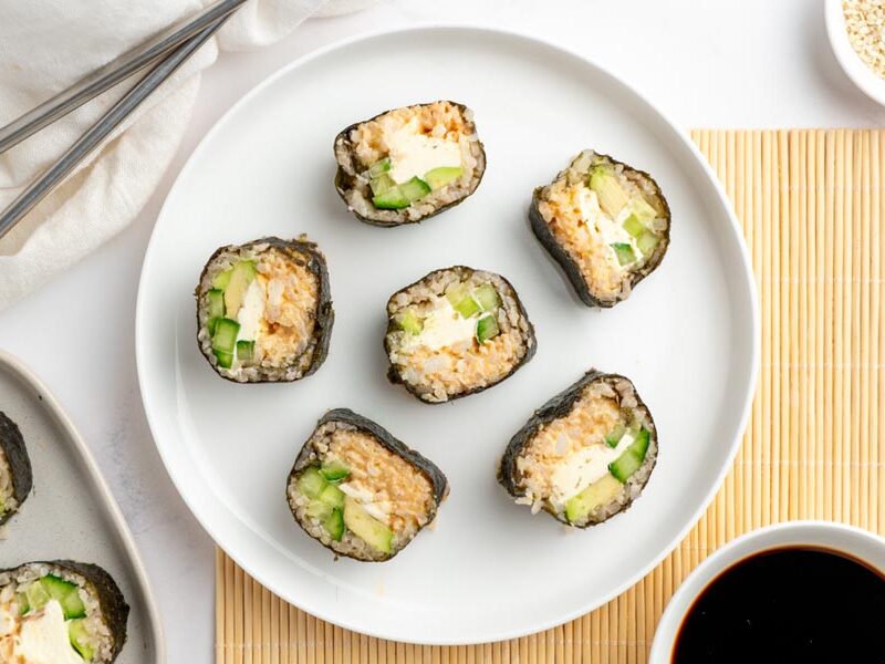 Keto sushi rolls with crab, cream cheese, cucumber and avocado beside soy sauce.