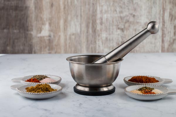 spices on table with large mortar and pestle