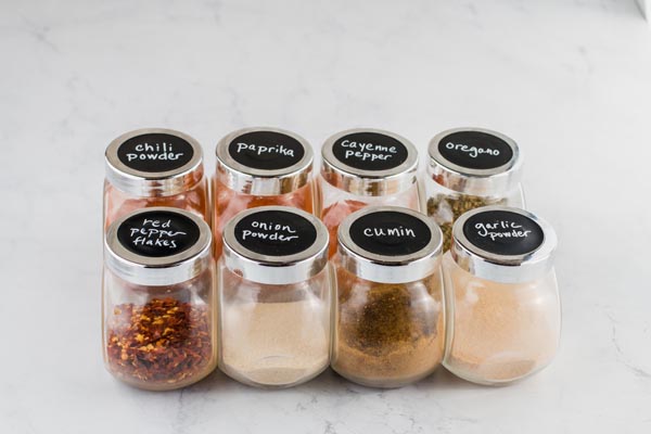 a number of spices in jars in a row