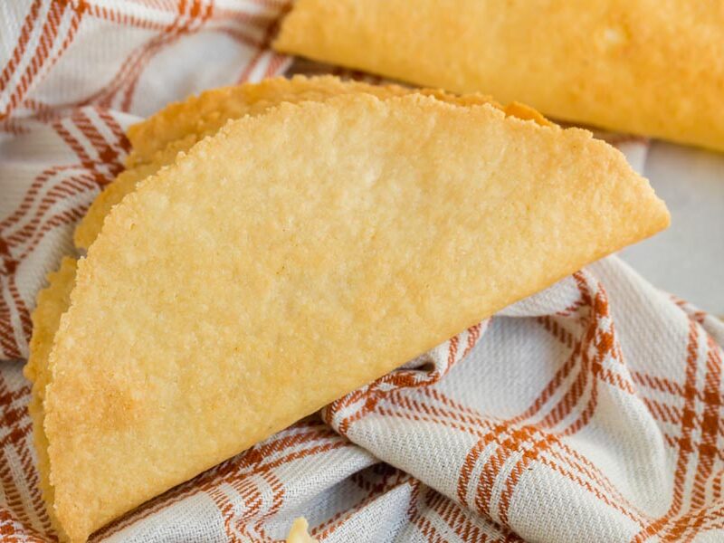 a hard shell taco on a plaid orange and cream napkin