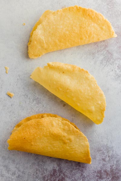 three crispy taco shells in a row