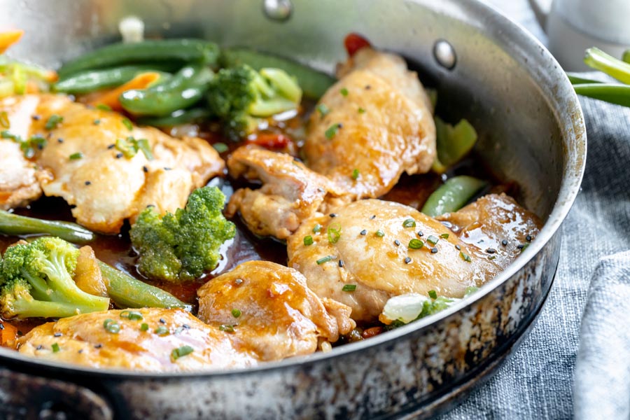 cooked chicken teriyaki in a skillet with broccoli and green beans