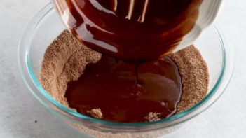 overhead shot of a clear bowl with cocoa based dry ingredients