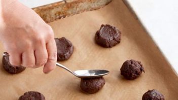 mixing chocolate cookie dough with a silver electric mixer