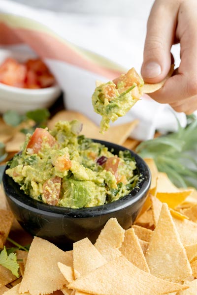 scooping guacamole out with a chip