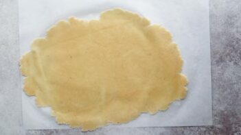thinly rolled out dough on a sheet of parchment paper
