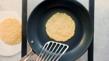 Using a spatula to flip a tortilla in a non-stick skillet.
