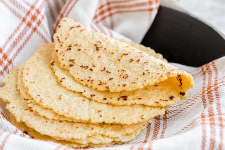 A soft tortilla folded on itself, draped over more tortillas.