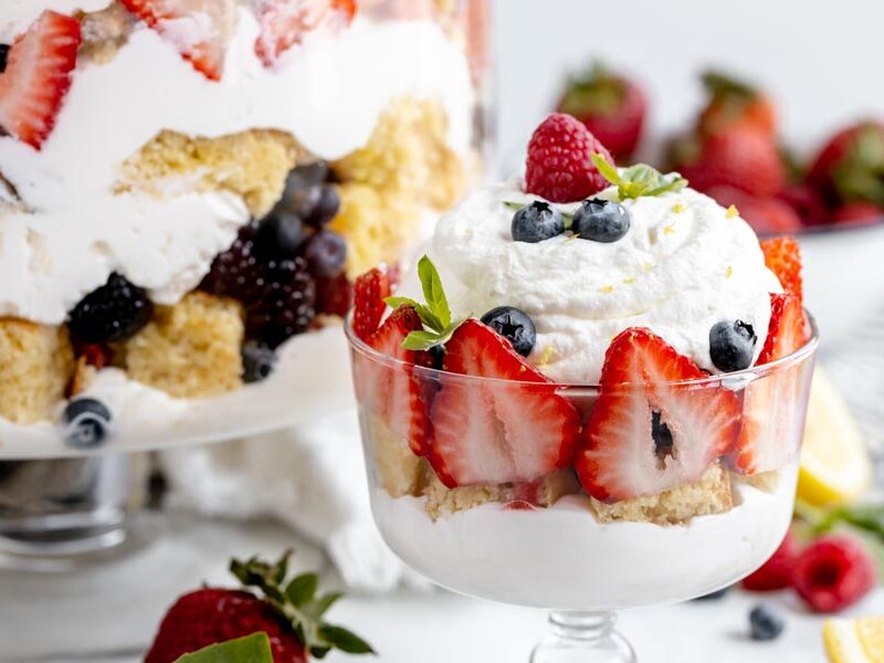 a small trifle dish with whipped cream, cake and strawberries