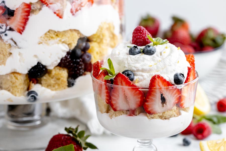 a small trifle dish with whipped cream, cake and strawberries