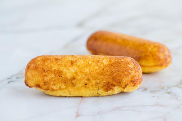 two baked twinkies on a marble surface
