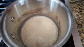 Cream and milk heating in a saucepan to make the custard base for keto Twix ice cream.