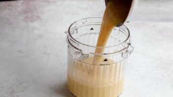 Cooked keto ice cream custard being poured into a blender before adding the protein powder.