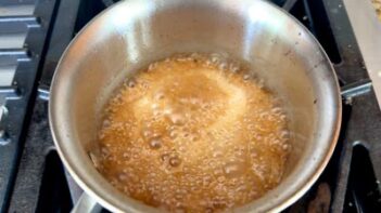 Sugar-free caramel sauce bubbling in a saucepan until thick and golden.