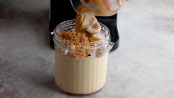 Cookie crumble and caramel being added to the churned keto Twix ice cream.