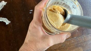 A scoop of creamy keto Twix ice cream with caramel and cookie pieces ready to serve.