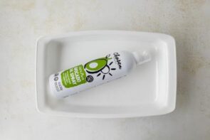 A can of avocado spray in a white casserole dish.