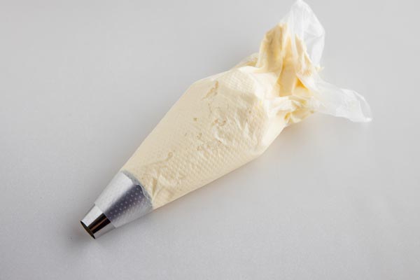 cream cheese frosting in a piping bag with a tip