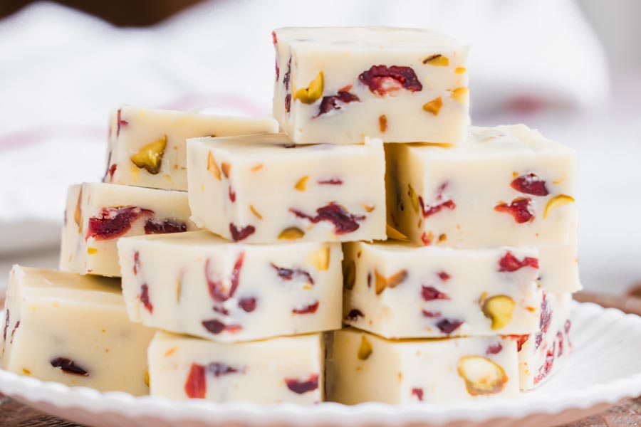 A plate piled high with white chocolate cranberry pistachio fudge pieces.