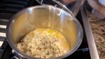 White chocolate chips melt into warm butter in a saucepan.