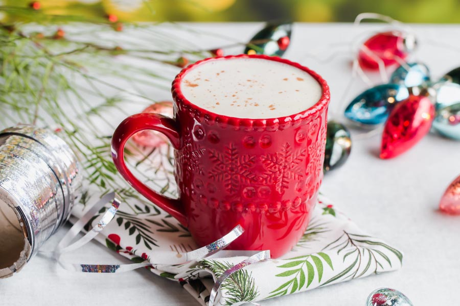 red mug of keto white hot cocoa while wrapping presents