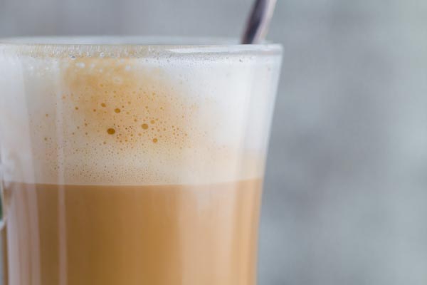 frothy white mocha in a mug with a spoon