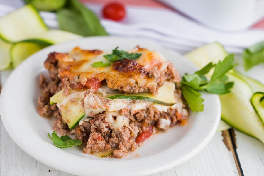 layers of beef, tomato, cheese and zucchini make up a slice of lasagna