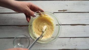 whisking white sauce in a clear bowl