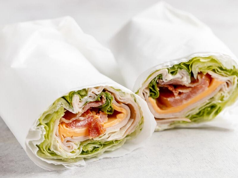 Two lettuce wrap halves with turkey, cheddar, bacon, and tomato