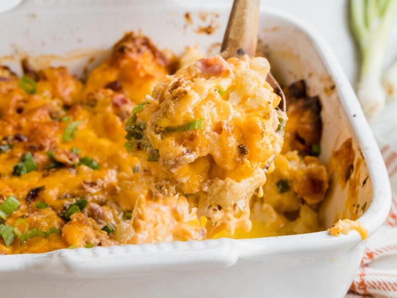 looking at a spoonful of cheesy casserole topped with green onion
