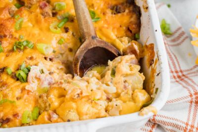 digging in a casserole to get a spoonful of a cheesy casserole