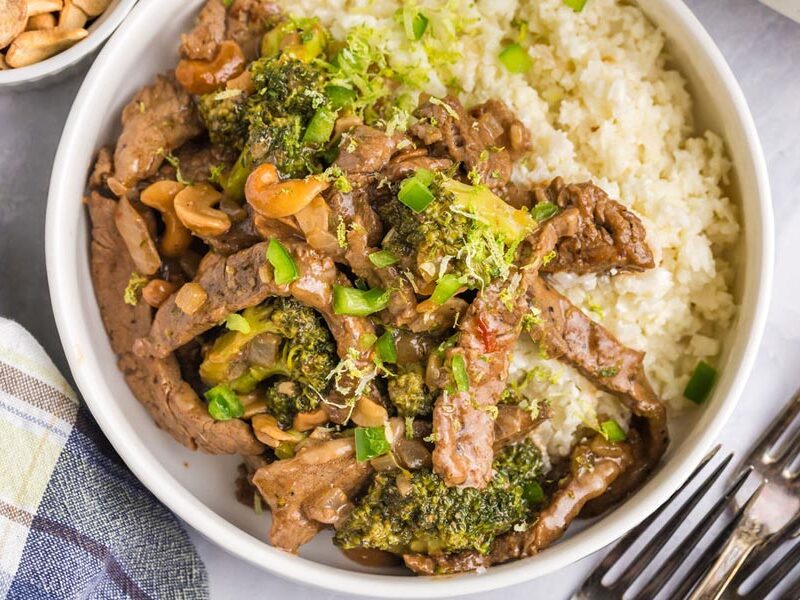 Juicy and saucy chinese cashew beef over coconut rice in a bowl.