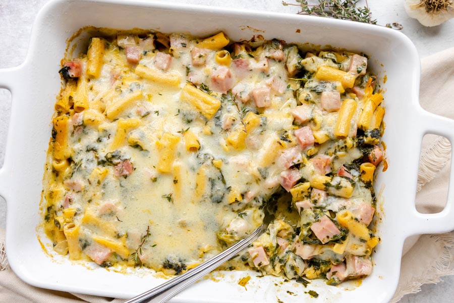 Overhead view of ham and Swiss ziti casserole baked until bubbly and golden in a white baking dish.
