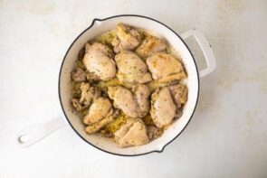 Cooked chicken thighs in a skillet.