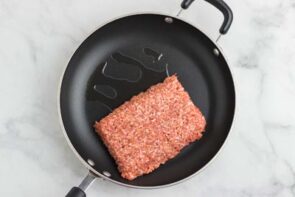 A pound of ground sausage in a skillet.