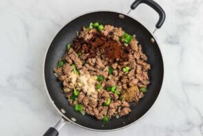 Cook sausage mixed with bell pepper and topped with seasonings.