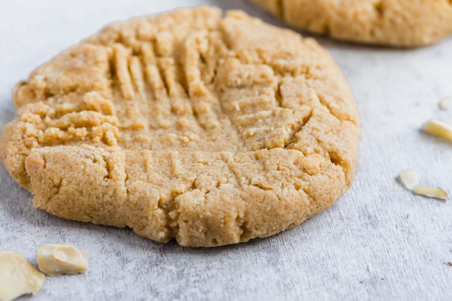 two peanut butter cookies with the crisscross fork pattern on top