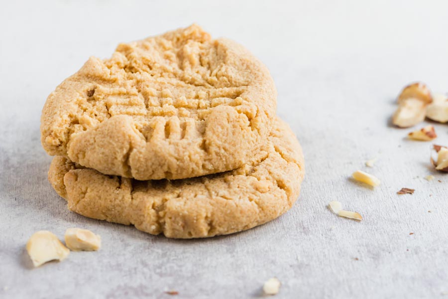a stack of two cookies with nuts near by
