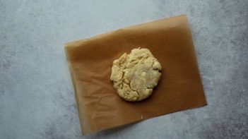 a baked cookie with white chips on parchment paper