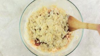 almonds in a bowl with a wooden spoon
