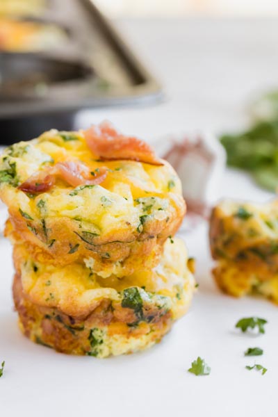 egg frittatas with parsley, spinach and bacon stacked on each other
