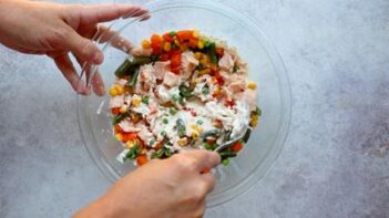 Chicken, mixed vegetables, and homemade cream of chicken soup being stirred together for the mini pot pie filling.