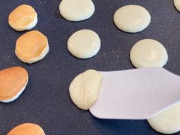 turning mini keto pancakes with a rubber spatula